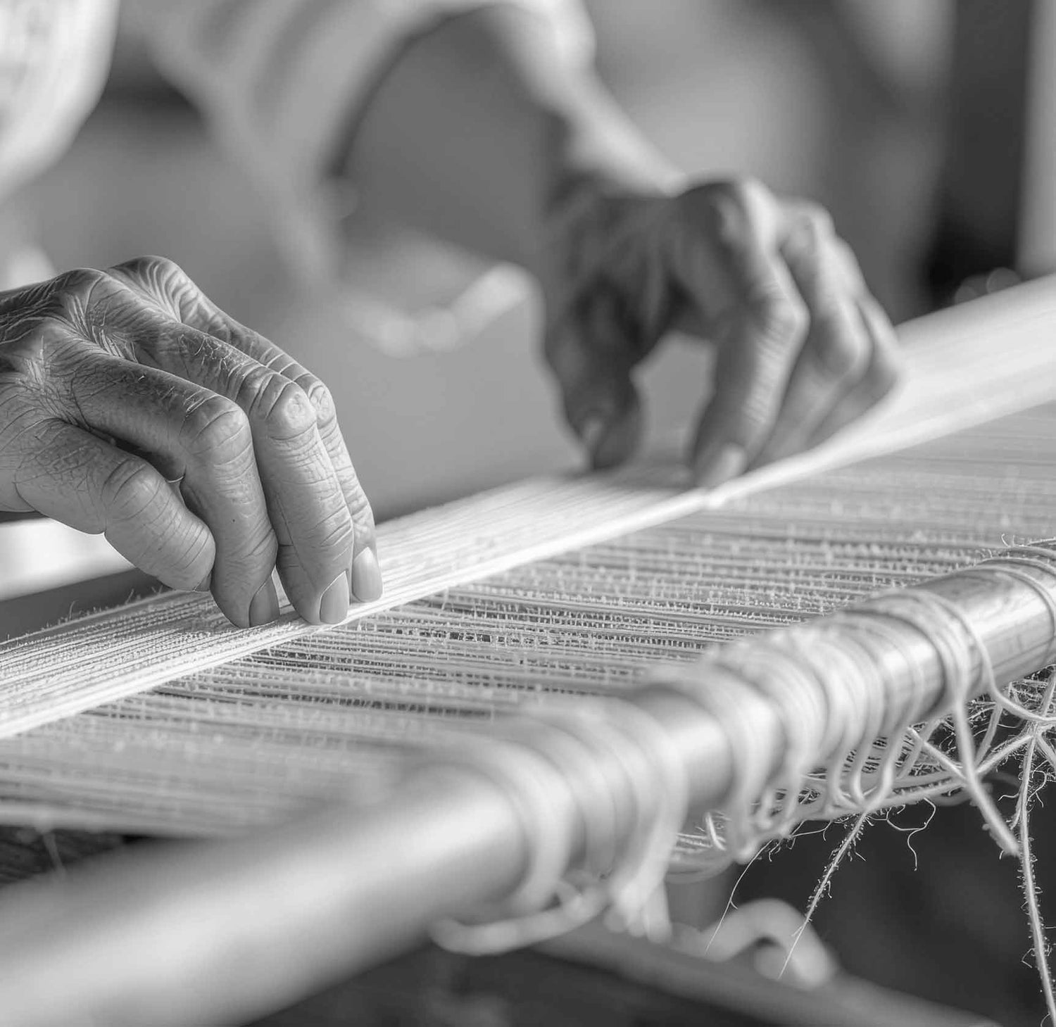 A woman weaving on a loom in a rustic setting with stone walls and natural elements. Sardinian artisan weaving traditional fabric on a loom for the sustainable fashion brand Antonello Tedde.