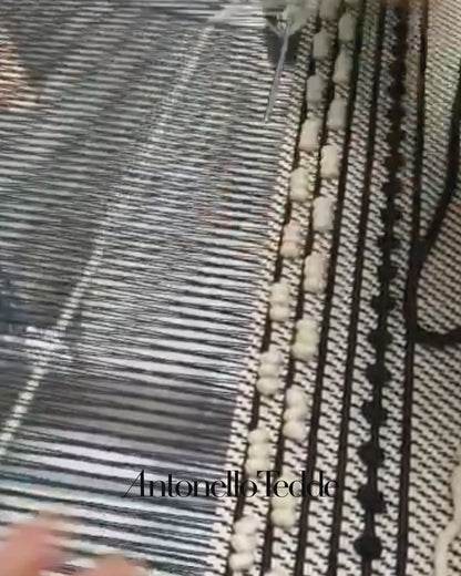 Close-up of a loom with threads and wooden beams where ANTONELLO TEDDE fabrics are made 