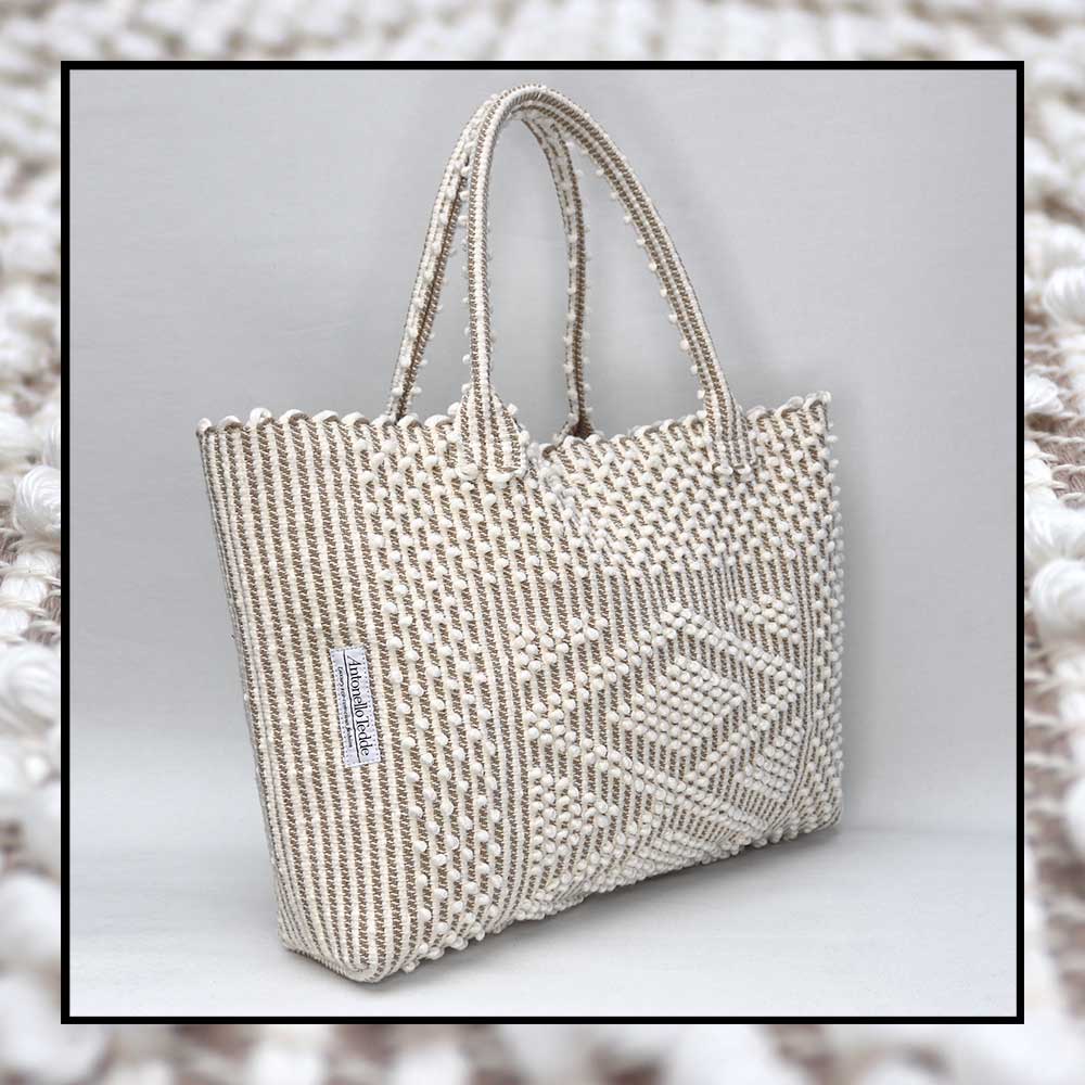 Antonello Tedde tote bag is made using hand woven fabrics Made of Italian Linen and regenerated Cotton , it is unlined with a practical inner pocket and a diamond pattern. A magnet fastens the bag keeping it secure. The bag is made using authentic Sardinian hand weaving methods in ethically managed factories. 