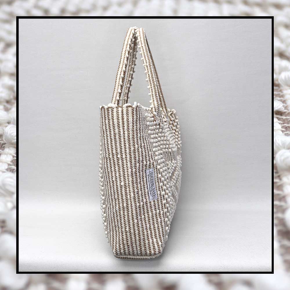 Antonello Tedde tote bag is made using hand woven fabrics Made of Italian Linen and regenerated Cotton , it is unlined with a practical inner pocket and a diamond pattern. A magnet fastens the bag keeping it secure. The bag is made using authentic Sardinian hand weaving methods in ethically managed factories. 